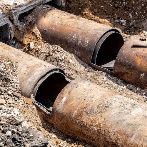 large rusted pipes that are part of a sewer line