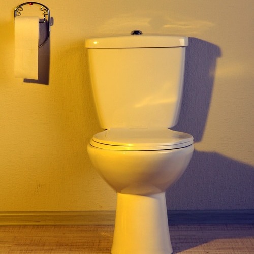 a toilet in yellow light