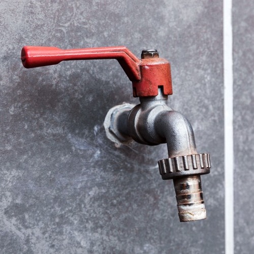 a tap against a concrete wall