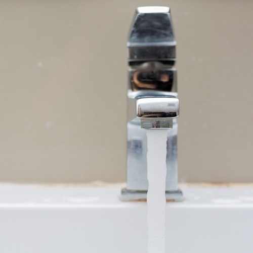 water flowing from a silver faucet