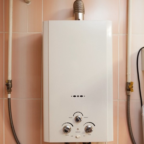 tankless water heater against a pink wall